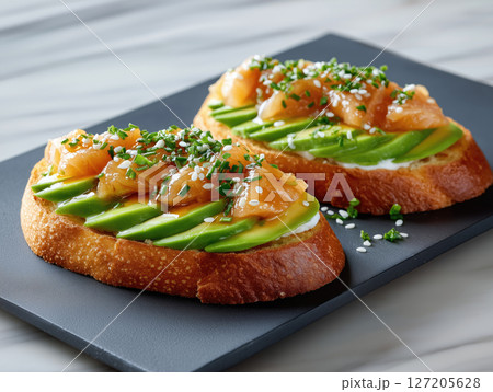 Delicious open-faced sandwiches topped with smoked salmon and avocado 127205628
