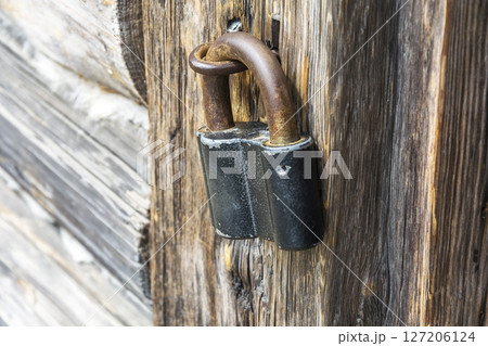 Wooden door closed on the old padlock, close-up, side view Wooden door closed on the old padlock, close-up, side view 127206124