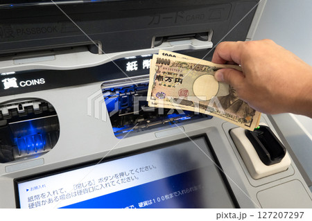 ATMに現金を投入するシーン 詐欺犯罪のイメージ ATMに現金を投入するシーン 詐欺犯罪のイメージ 127207297