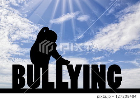 Silhouette of a sad and lonely girl child sitting on the word bullying against the sky Silhouette of a sad and lonely girl child sitting on the word bullying against the sky 127208484