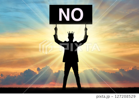 Selfishness. Selfish man with a crown on his head, holding a poster with the word no. 127208529