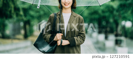雨の中で傘をさす女性（梅雨・6月） 127210591