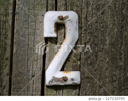 Old vintage number two door plate on old wooden fence 127210793