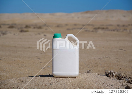 White plastic bottle stands in desert White plastic bottle stands in desert 127210805