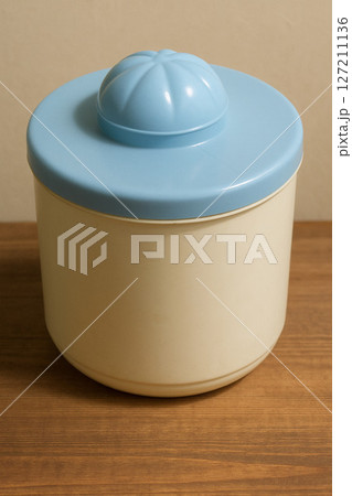 Plastic Food Container with Blue Lid on Wooden Table  Minimalist Home Storage Concept 127211136