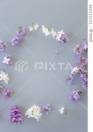 Lilac bouquet from above on a minimalistic gray background for design 127211358