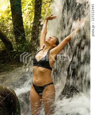 Woman Enjoying the Waterfall 127212445