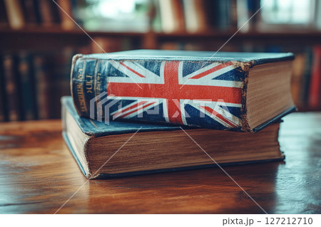 Books with british flag on wooden surface in library 127212710