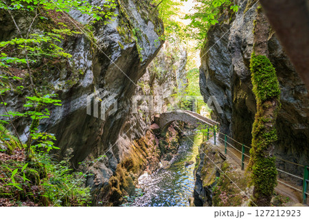 Old small stone bridge over river at Gorges de l'Areuse, Switzerland 127212923