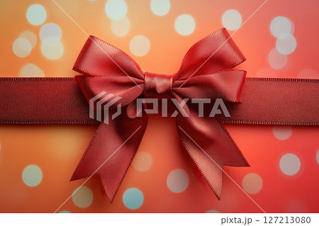 Red satin bow with ribbon on blurred red background with bokeh. Generated by artificial intelligence 127213080