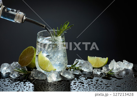 Gin and tonic cocktail made with dry gin, tonic water, lime, and ice. Gin and tonic cocktail made with dry gin, tonic water, lime, and ice. 127213428