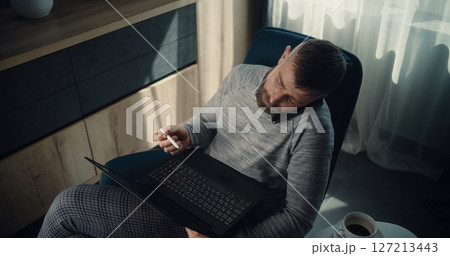 High Angle of Businessman Having Phone Call, Working on Laptop, Monitoring Real-Time Stocks 127213443