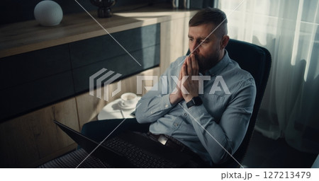 Stressed Financial Analyst Monitoring Real-Time Stocks Falling on Laptop, Soaking Financial Loss 127213479