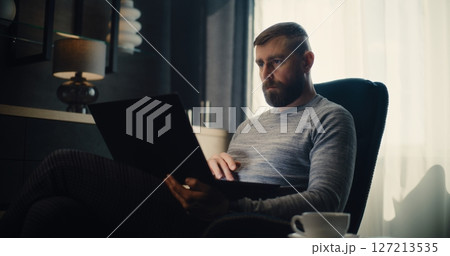 Financial Expert Working on Laptop, Monitoring Real-Time Stocks in Comfortable Office 127213535