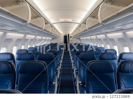 Interior view of airplane cabin with rows of passenger seats, commercial aircraft seating, air travel concept, aviation industry 127213869