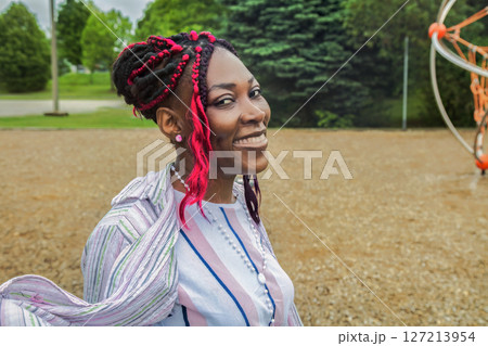 Happy African American woman enjoying relaxing day walking at outdoor park playground smiling Happy African American woman enjoying relaxing day walking at outdoor park playground smiling 127213954