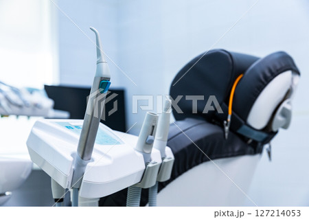 Modern dental equipment in a clinic setting showcasing advanced instruments and a comfortable patient chair prepared for treatment in a bright, clean environment 127214053
