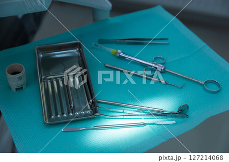 An Array of Surgical Instruments on a Bright Teal Surface in a Medical Environment for Dental or Surgical Procedures Displaying Precision Tools for Healthcare Professionals 127214068