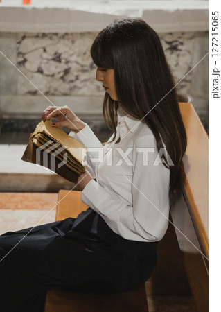 Woman Flipping The Pages Of The Old Sacred Book While Sitting In Church Woman Flipping The Pages Of The Old Sacred Book While Sitting In Church 127215065