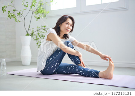 ヨガウェアでヨガをする50代女性 ヨガウェアでヨガをする50代女性 127215121