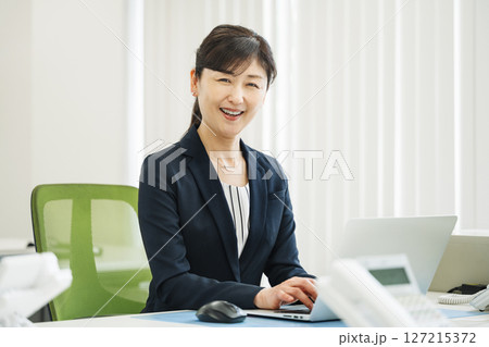 ビジネスオフィスで生き生きと働く50代のキャリアウーマン 127215372