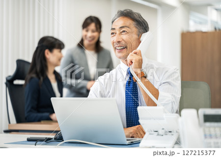 オフィスで電話をする営業職のシニア男性 127215377