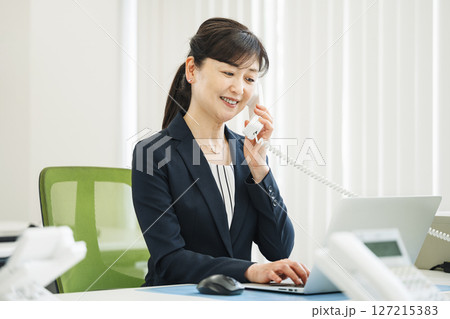 オフィスで電話をする50代のキャリアウーマン 127215383