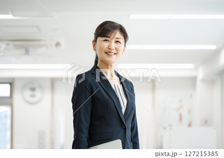 オフィスで働く50代のキャリアウーマン オフィスで働く50代のキャリアウーマン 127215385