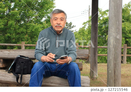 旅先の公園で一服しながら道順を確認しているお爺ちゃん 127215546