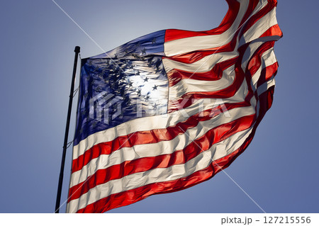 Dramatic Backlit American Flag Waving in the Wind. Dramatic Backlit American Flag Waving in the Wind. 127215556