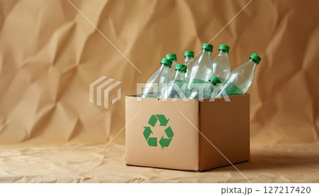 A cardboard box filled with recycled plastic bottles, highlighting eco-friendly efforts for a sustainable environment 127217420