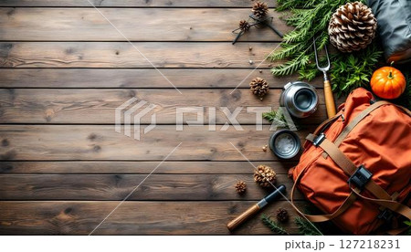 A wooden floor showcases a travel backpack and hiking equipment, ready for a camping trip or forest hiking adventure 127218231