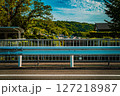 ガードレール越しに望む郊外の山と町の風景 127218987