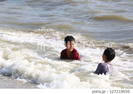 Joyful Children Playing in Shallow Sea Waves, Laughter and Fun at the Beach on a Sunny Day, Childhood Memories of Freedom and Happiness Joyful Children Playing in Shallow Sea Waves, Laughter and Fun at the Beach on a Sunny Day, Childhood Memories of Freedom and Happiness 127219050