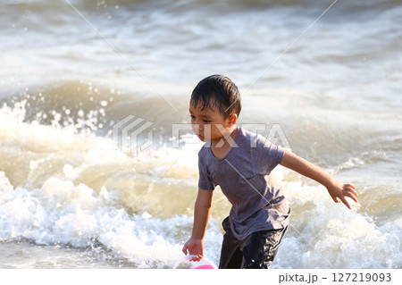 Young boy playing joyfully at the beach, splashing water with a playful expression while enjoying a sunny day by the shore, embodying the spirit of childhood spontaneity. Young boy playing joyfully at the beach, splashing water with a playful expression while enjoying a sunny day by the shore, embodying the spirit of childhood spontaneity. 127219093