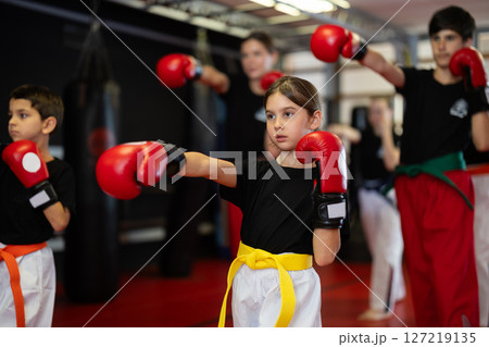 Group of children and teenagers train with boxing gloves 127219135