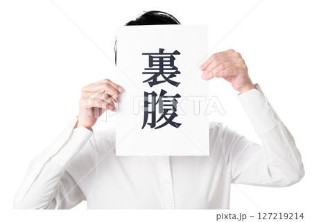 裏腹と書かれた紙を持つ白いシャツを着た人物 127219214