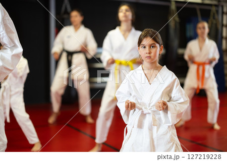 Teenage girl in kimono at karate lesson Teenage girl in kimono at karate lesson 127219228