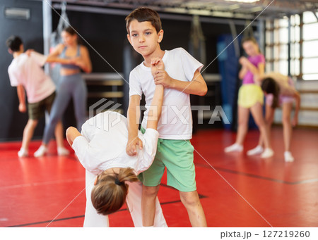 Teenage girl sparring with boy during training 127219260