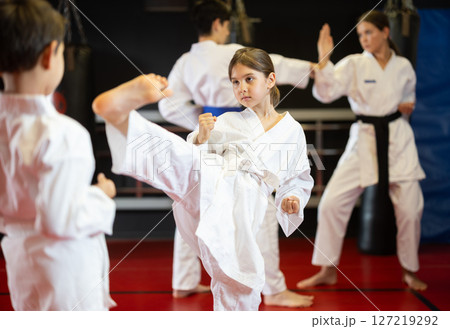Boy and girl train to perform defensive karate installations and attacking combat techniques 127219292