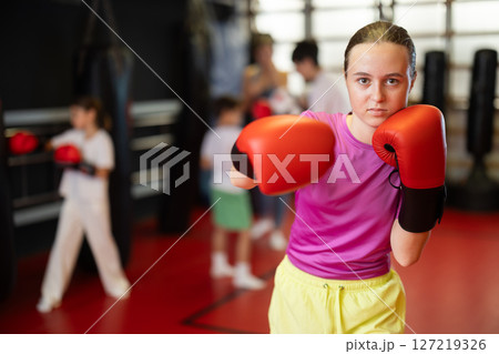 Teen girl with boxing gloves in gym Teen girl with boxing gloves in gym 127219326