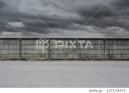 Concrete wall and the rain clouds are coming sky background. Concrete wall and the rain clouds are coming sky background. 127219372
