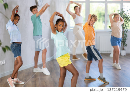 Active preteen children practicing Hip-hop dance with young trainer 127219479