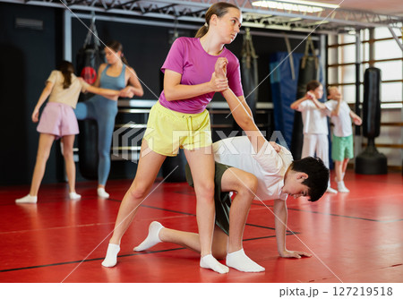 Teenage boy and girl practice self-defense in pairs 127219518