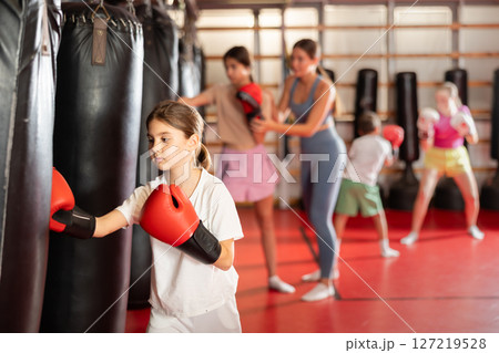 Teen girl in boxing gloves in training 127219528