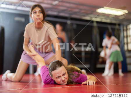 Purposeful engrossed teen girls train during self-defense fight training session in gym Purposeful engrossed teen girls train during self-defense fight training session in gym 127219532