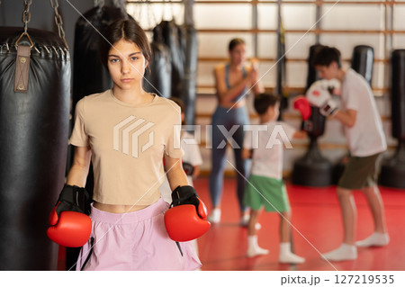 Girl posing during training in boxing gloves 127219535