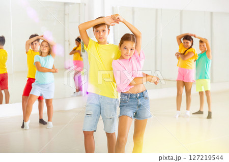 Young boys and girls dancing salsa in dance room Young boys and girls dancing salsa in dance room 127219544