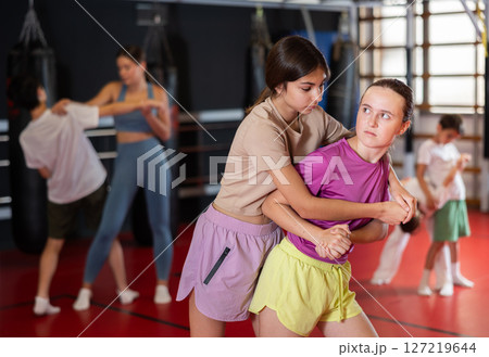 Girls practice self-defense strikes in the gym 127219644