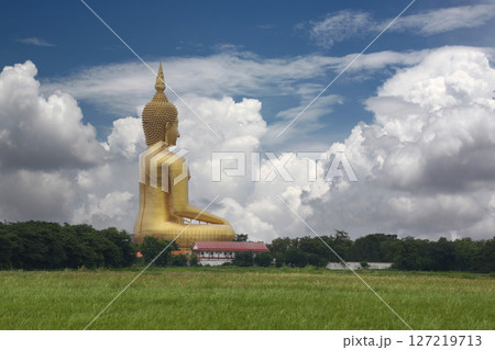 Golden Buddha Statue Against Blue Sky and white clouds Golden Buddha Statue Against Blue Sky and white clouds 127219713